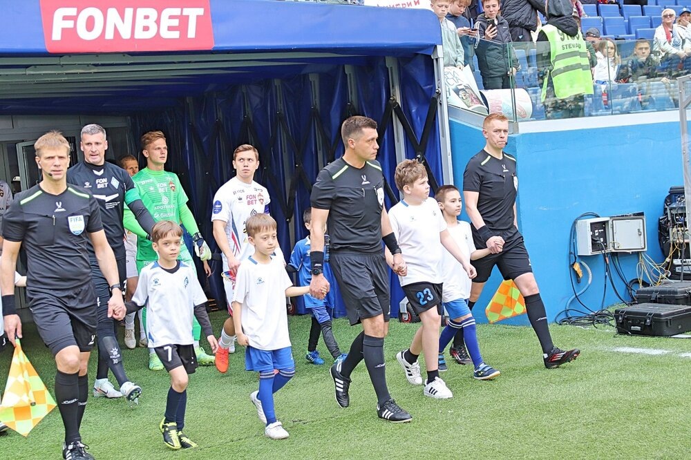 Бригада судей и стартовые составы команд выходят на поле.