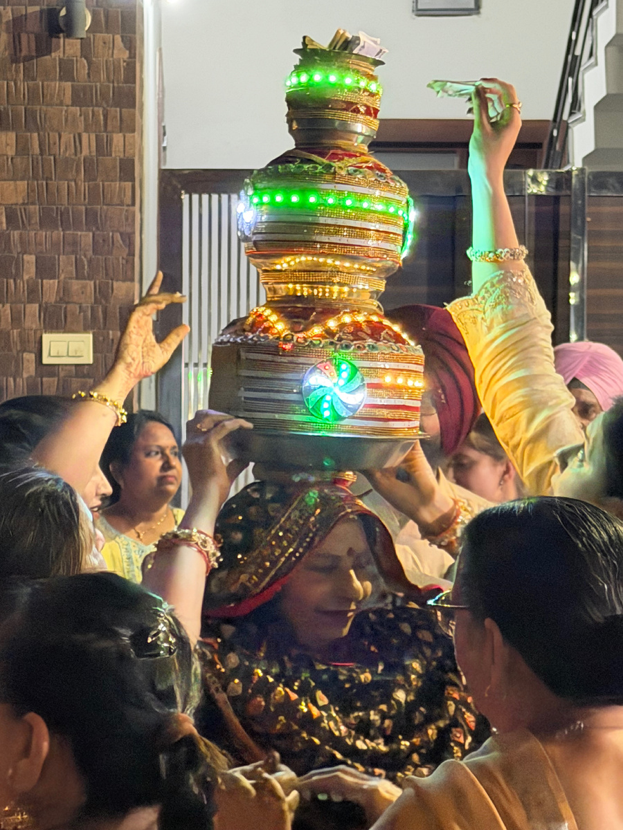 Невеста несёт ритуальный gharа — украшенный горшок с водой. Руки с мехенди поддерживают конструкцию со всех сторон. Курукшетра, апрель