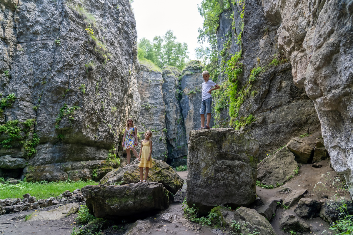 Мама с детьми гуляют в ущелье среди величественных отвесных скал. Источник: Shutterstock