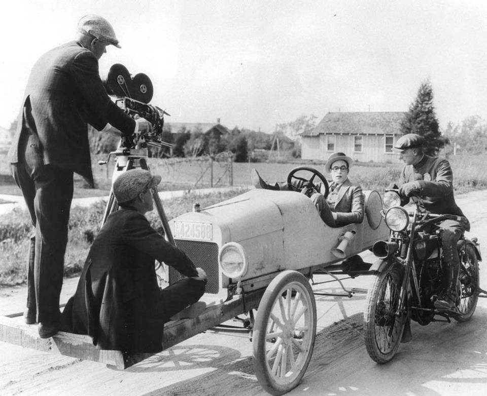 Гарольд Ллойд за рулем собственного автомобиля. Фильм "Первокурсник", 1925 год. Для съемок крупного плана во время движения камера была установлена на специальную платформу, прикрепленную прямо к передней части автомобиля. Справа на мотоцикле загримированный полицейский.