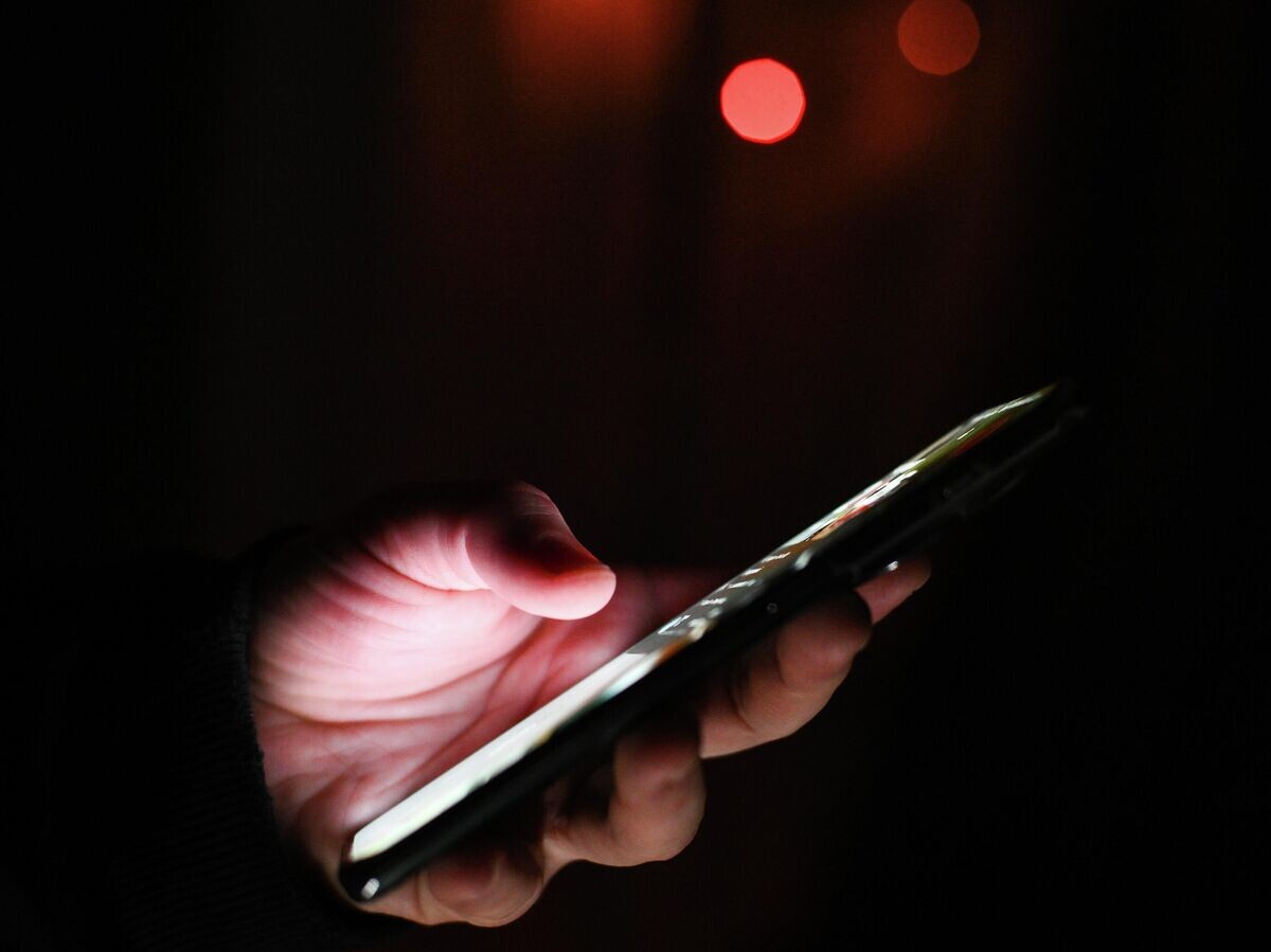    Мужчина держит в руках мобильный телефон | © РИА Новости / Владимир Астапкович