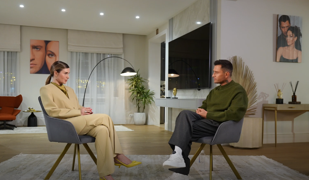 Лаура Джугелия и Павел Прилучный сидят напротив друг друга. Обратите внимание на фотографии Павла и Зепюр на стенах. Очень интерсный ракурс был выбран. 