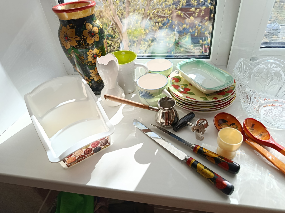 Ваза и ножи хохлома, современные кружки 2000-2020-х, турка нержавейка, вроде, современные тарелки с принтами, мамина селедочница из фаянса (ну я помню. что там постоянно селедка с луком кольцами подавалась))), нож консервный, ложки деревянные, подставка под яйцо и органайзер для специй современный.