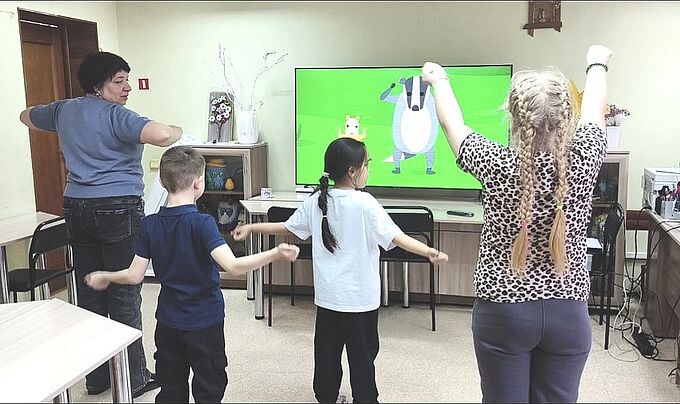 Дети выполняют движения вслед за персонажами мультфильма