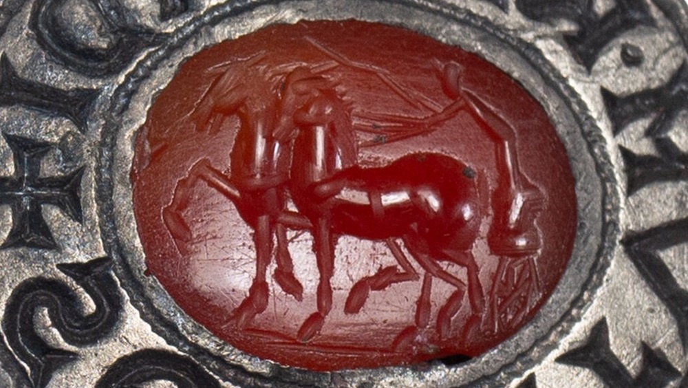 В центре — кусок сердолика, коричневато‑красного полудрагоценного камня.