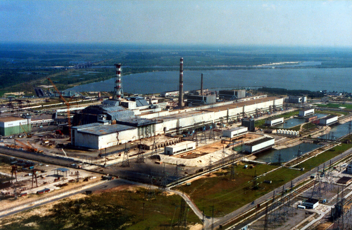 Слева - 4й блок под саркофагом. Авторство: IAEA Imagebank. 04710018, CC BY-SA 2.0, https://commons.wikimedia.org/w/index.php?curid=58287179