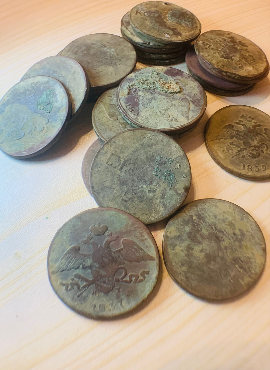 На деревянном столе россыпью лежат 25 темно-коричневых, почти черных кружков. 