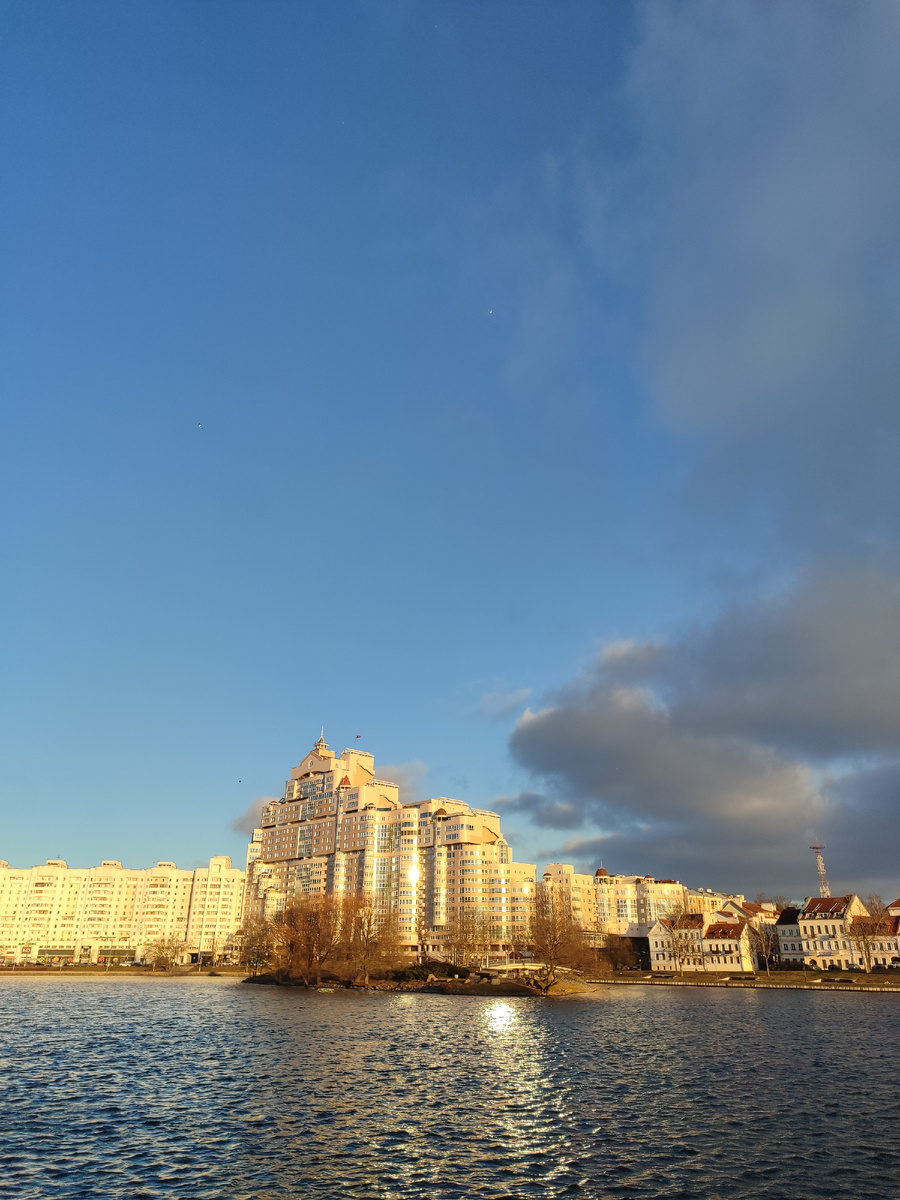 Мне нравится вид через реку Свислочь в этом месте. Видно как бы и новый, и старый Минск одновременно. Справа на фотографии виднеется небольшой, почти игрушечный исторический квартал, а сразу рядом - огромное бетонное строение. Контраст. 