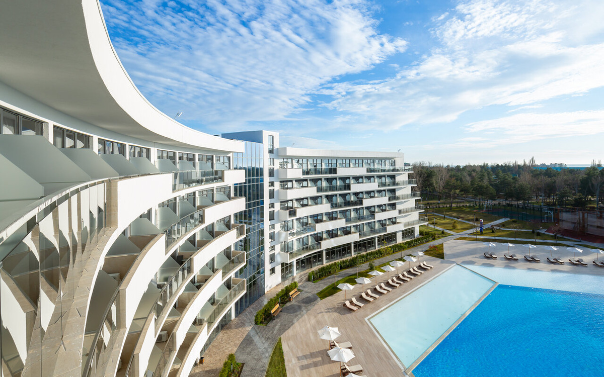 Архитектура в стиле хай-тек и каскад открытых бассейнов в Mövenpick Resort & SPA Anapa Miracleon 5* на Пионерском проспекте, 253. Отель расположен на первой береговой линии и предлагает европейский уровень сервиса «все включено». В 2026 году это одна из самых востребованных локаций для премиального отдыха в Анапе с собственным оборудованным пляжем.

