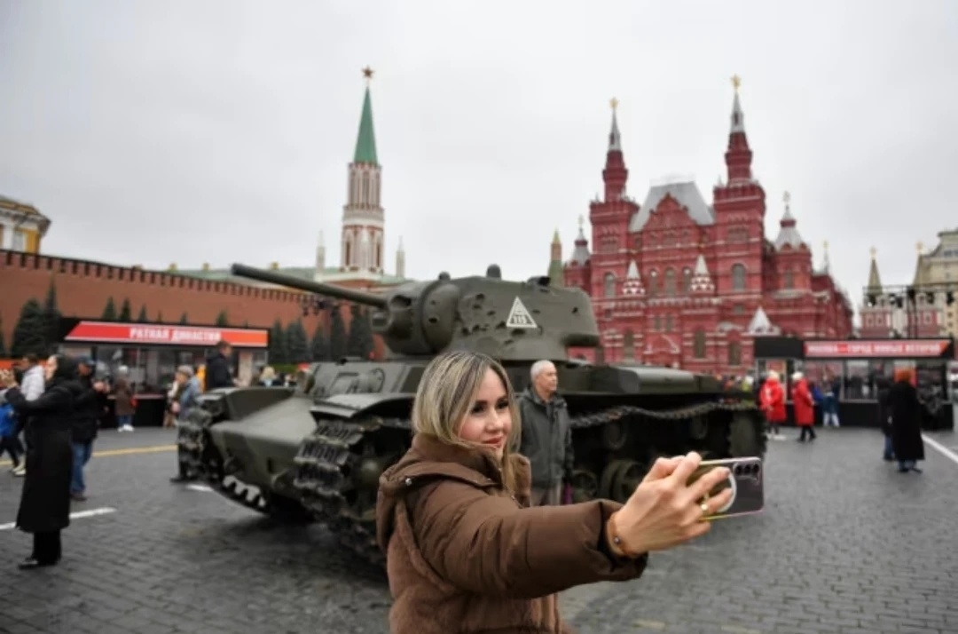 Женщина позирует для фотографий на открытой выставке, посвященной военному параду 1941 года, на Красной площади в Москве, Россия, 7 ноября 2025 года. (Фото Александра Землиниченко-младшего/Xinhua via Getty Images) Александр Землиниченко-младший/Синьхуа/Getty Images