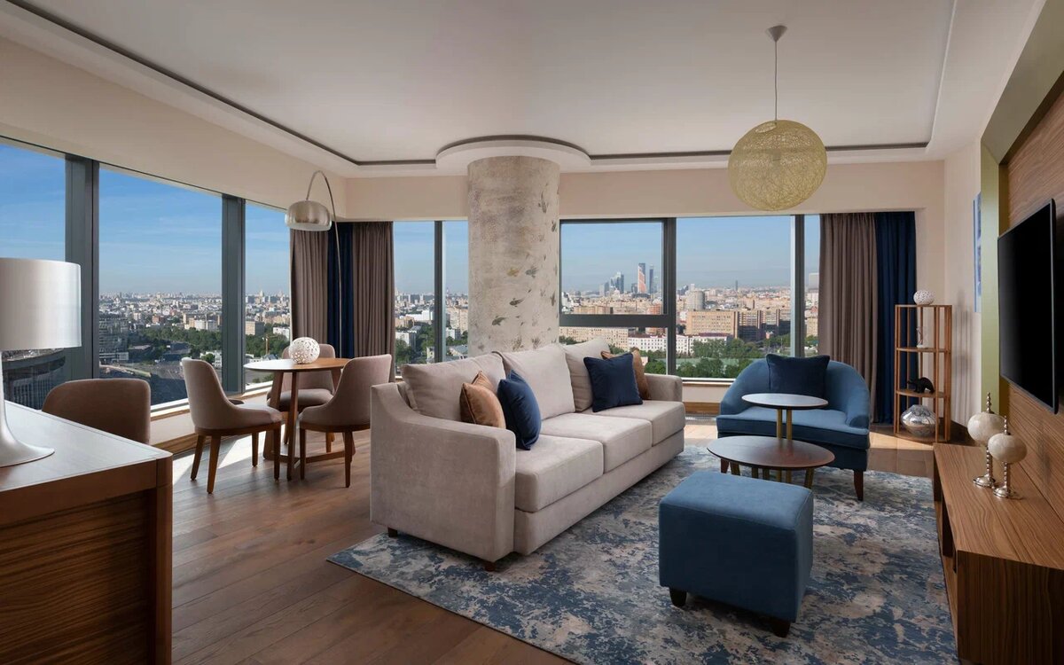Интерьер современного люкса в Radisson Blu Olympiyskiy Hotel 5* на улице Самарской, 1. Благодаря панорамному остеклению во всю стену, Москва здесь видна как на ладони: от сталинских высоток до башен Сити. В 2026 году этот отель выбирают те, кто ценит лаконичный скандинавский дизайн, безупречный сервис и возможность засыпать, любуясь огнями мегаполиса с высоты птичьего полета.