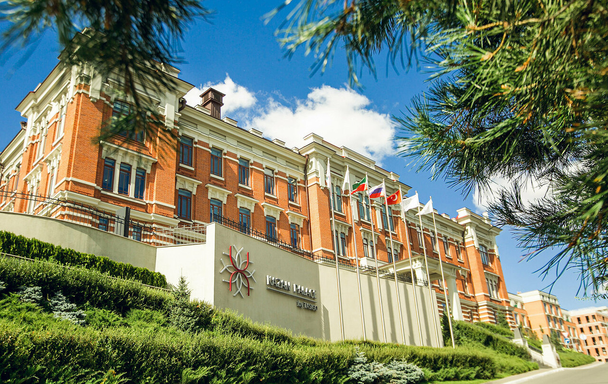 Исторический фасад отеля Kazan Palace by Tasigo 5* по адресу улица Калинина, 3Б. Здание бывшей Шамовской больницы, являющееся объектом культурного наследия, прошло полную реновацию и сочетает в себе аутентичную архитектуру начала XX века с современными интерьерными решениями. В 2026 году это актуальная локация для культурно-познавательного туризма и комфортного отдыха в Вахитовском районе Казани.
