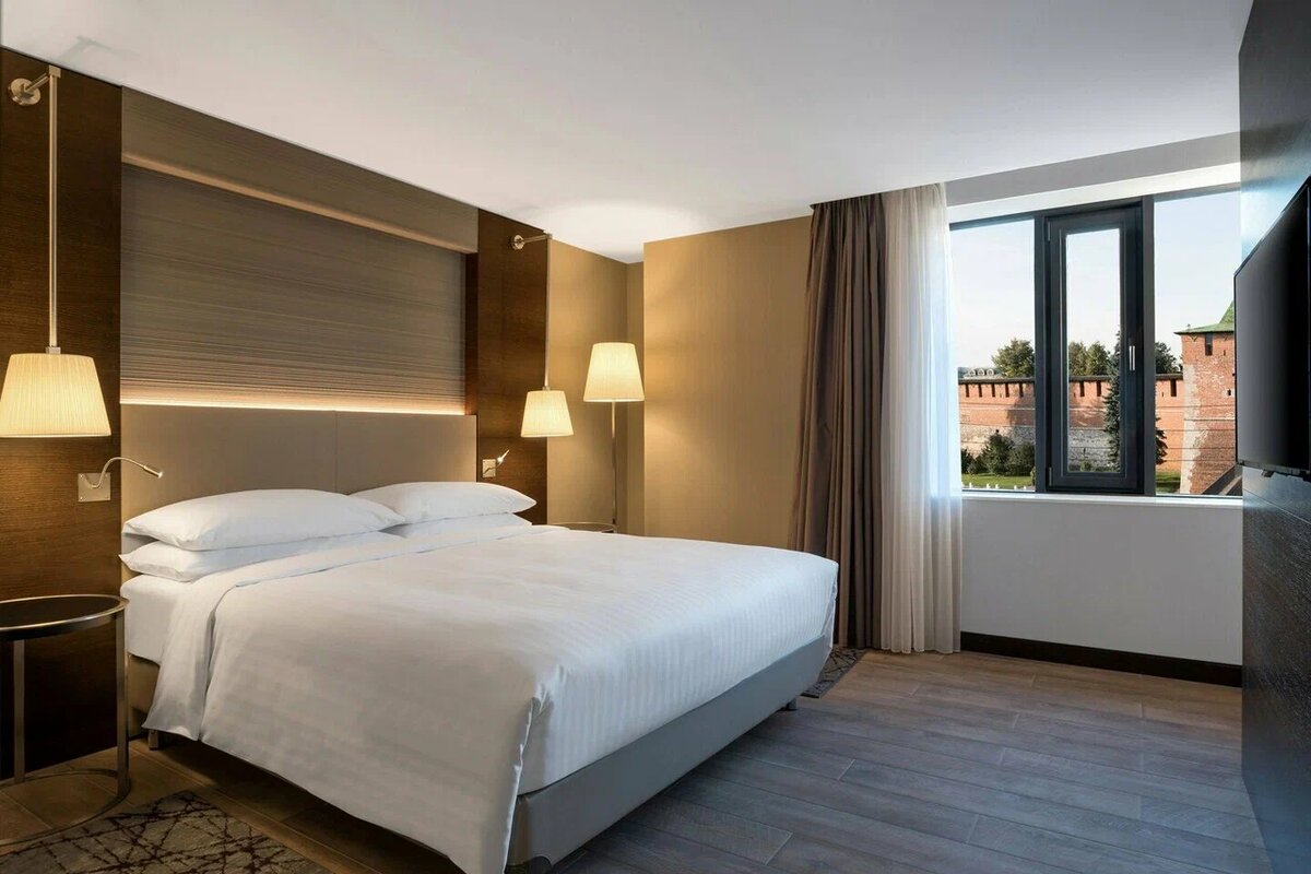Интерьер номера Sheraton Nizhny Novgorod Kremlin 5* на Театральной площади, 1 в Нижнем Новгороде. Отель расположен в историческом центре города, в непосредственной близости от входа в кремль и основных пешеходных маршрутов. В 2026 году этот объект остается востребованным для планирования поездок благодаря сочетанию высокого стандарта обслуживания и тихой атмосферы в самом центре.