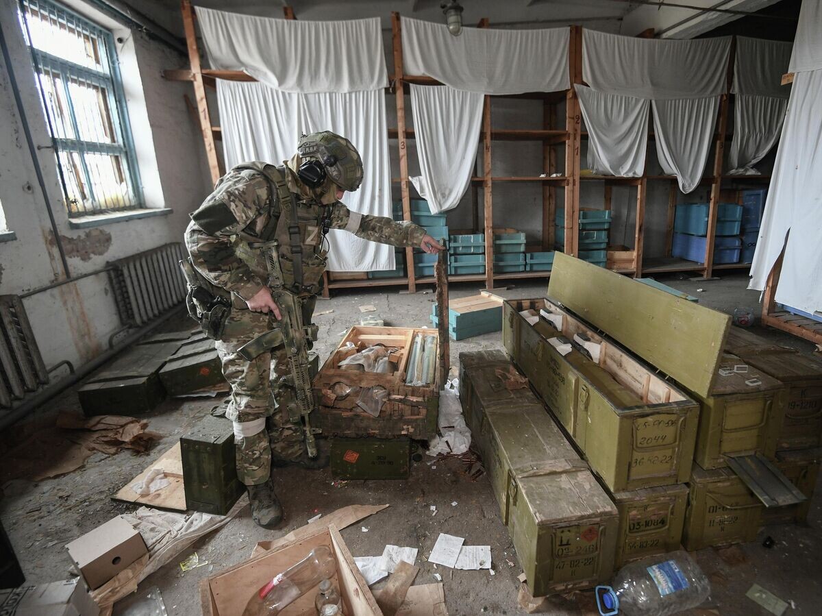    Военнослужащий ВС России осматривает боеприпасы, оставленные ВСУ в селе Александровка Херсонской области | © РИА Новости / Константин Михальчевский