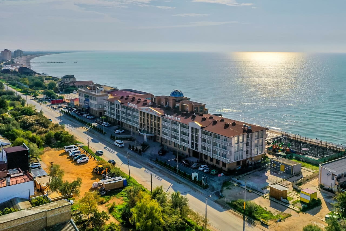 Фасад и панорамный вид на акваторию отеля Ribera Resort & SPA 4* на Симферопольской улице, 57 в Евпатории. Расположение на первой береговой линии в сочетании с наличием медицинского и SPA-центров обеспечивает условия для полноценного восстановления и круглогодичного отдыха. В 2026 году это востребованная локация для планирования тихого отдыха с доступом к собственной пляжной инфраструктуре и видовым характеристикам Западного Крыма.