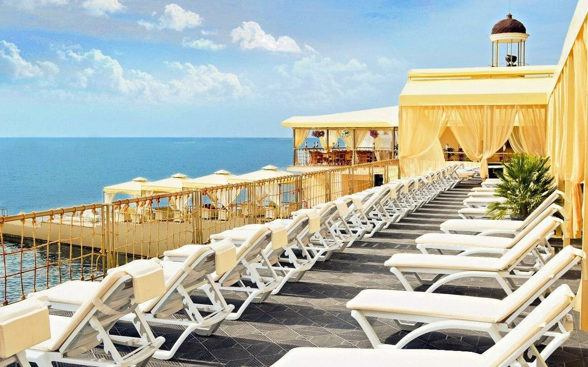 Многоуровневый пляжный комплекс парк-отеля Porto Mare 4* на улице Перекопской, 20/2 в Алуште. Обустроенная береговая зона с аэрариями и индивидуальными бунгало обеспечивает гостям условия для комфортного отдыха у моря с возможностью регулировать интенсивность инсоляции. В 2026 году это востребованная локация для планирования тихого семейного отдыха с доступом к развитому гостиничному сервису.