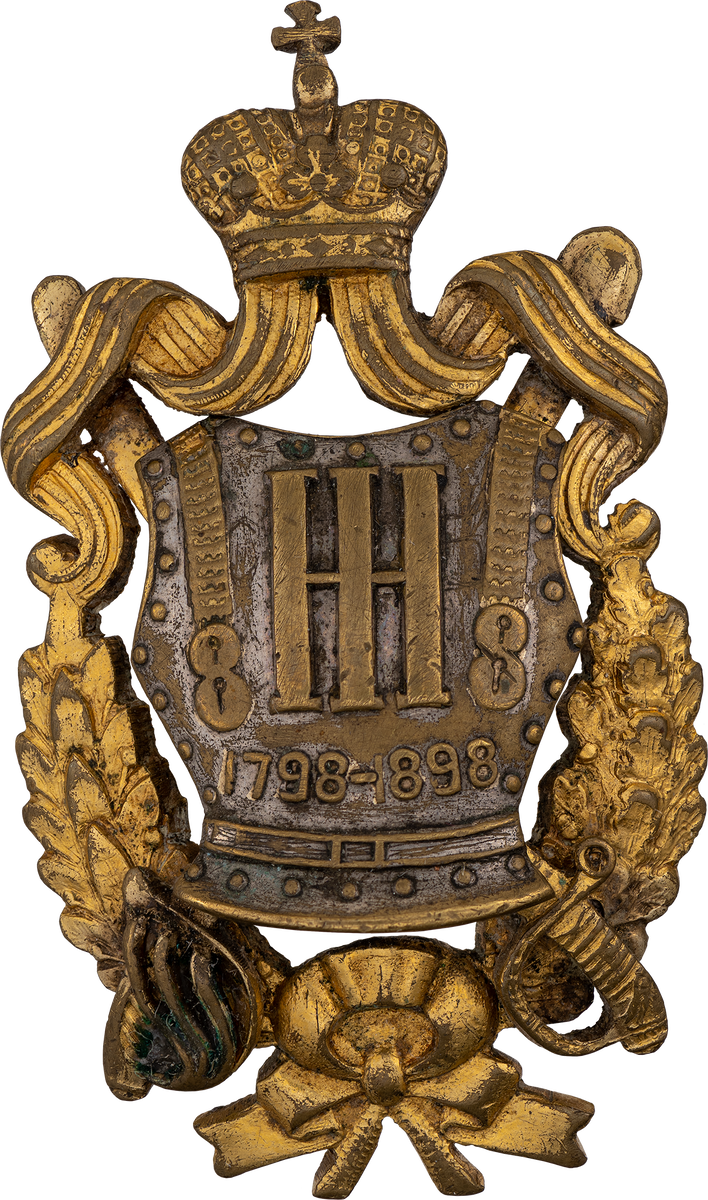 Нагрудный знак 8-го драгунского Астраханского Генерал-Фельдмаршала Великого Князя Николая Николаевича полка. Российская Империя. 1911 г. Недрагоценный металл; штамповка, монтаж, пайка. Нагрудный знак утвержден 14 сентября 1911 года. Основа знака — кираса, наложенная на скрещенные палаш и шашку. Кираса увенчана императорской короной с георгиевскими лентами. В центре кирасы — вензель великого князя Николая Николаевича. Даты: «1798» — старшинство полка; «1898» — год его 100-летнего юбилея. Ссылка: https://rm.shm.ru/core/item/81 Старшинство — 20.08.1798, по Новоархангельскому драгунскому полку. Для справки: 12.10.1811 — генерал-майором Бороздиным 2-м в м. Усвяты Велижского уезда Витебской губернии из офицеров и нижних чинов, отделённых от лейб-кирасирского Его Величества, лейб-кирасирского Её Величества, Екатеринославского кирасирского, Рижского, Казанского, Ямбургского, Нежинского, Псковского, Московского, Финляндского и Митавского драгунских, Гродненского, Елисаветградского и Изюмского гусарских полков сформирован Астраханский кирасирский полк в составе 5-ти эскадронов (ПСЗ, XXXI, 24808). Ссылка: https://ru.wikipedia.org/wiki/Астраханский_8-й_драгунский_полк 12 октября 2026 года исполняется 215 лет со дня сформирования Астраханского кирасирского полка.