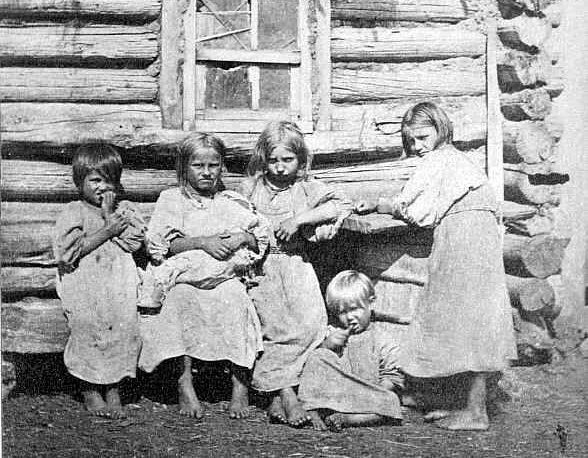 На старых фотографиях часто видно: девочка нянчит младенца — и это не игра, а настоящая работа.