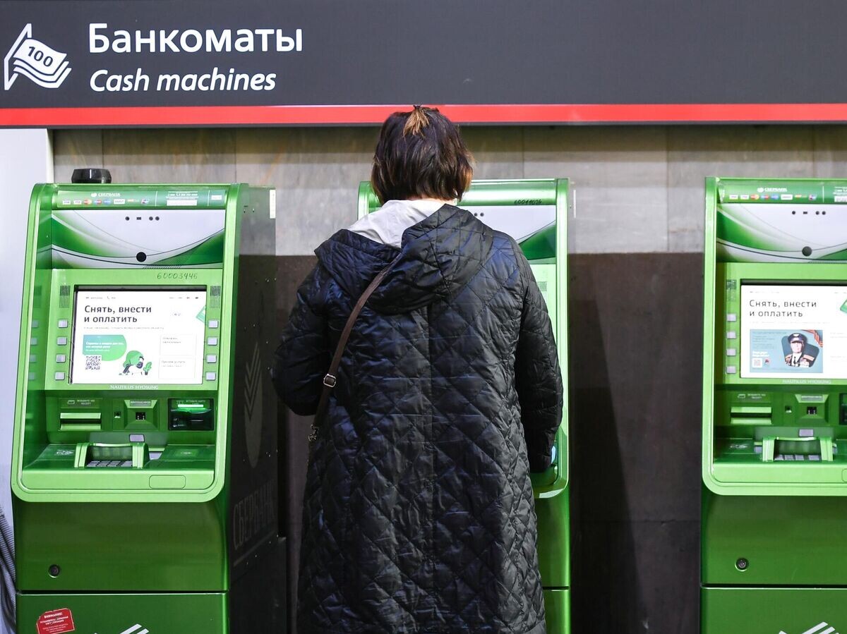    Женщина возле банкоматов на улице Москвы | © РИА Новости / Константин Михальчевский