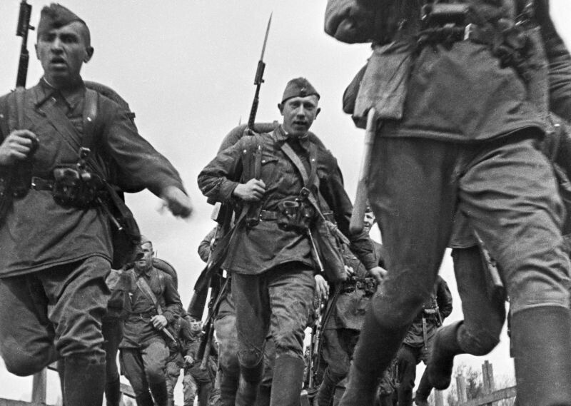 Бойцы Ленинградского фронта с винтовками СВТ-40 пробегают по мосту, 1942 год. Фото: Анатолий Гаранин. 