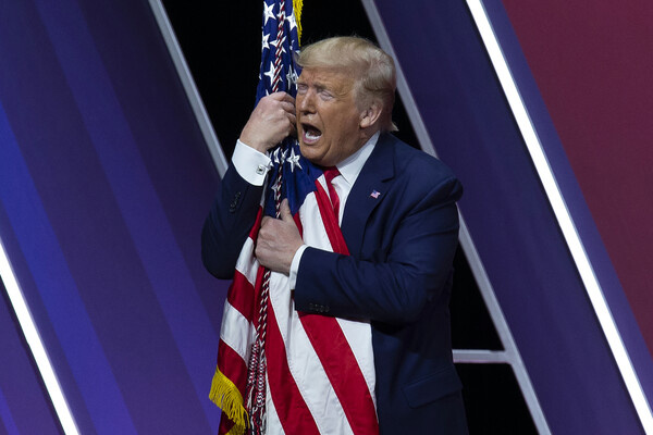 Президент США Дональд Трамп обнимает национальный американский флаг. Оксон-Хилл, США. 29 февраля 2020 года. / Jose Luis Magana/AP   📷
