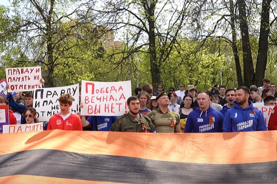    Активисты растянули большую георгиевскую ленту у посольства Германии в знак протеста против запретов символов Победы. Фото: «Молодая Гвардия Единой России» ДНР