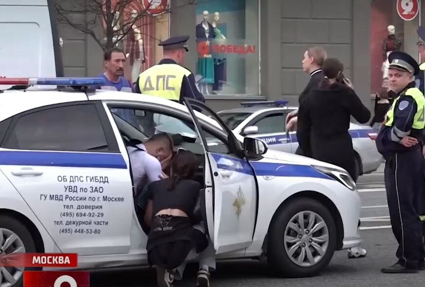 Наряд ДПС оформляет ДТП. В машине ГАИ — мотоциклист. Кадр из репортажа Рен-ТВ