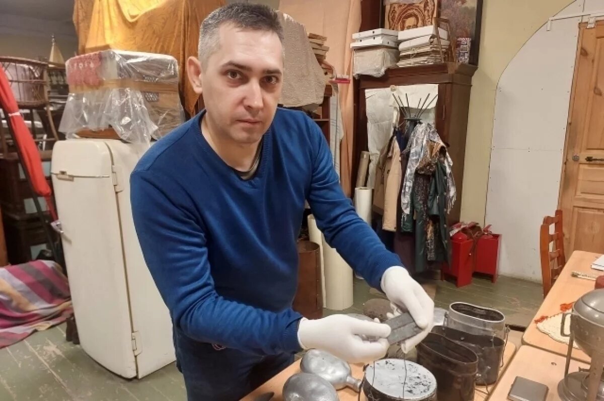    Хранитель коллекции Александр Королёв показывает шейный жетон узника фашистского концлагеря.