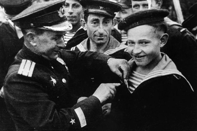 1 мая 1944 года. Командир бригады торпедных катеров Северного флота Александр Кузьмин вручает юнге Саше Ковалеву орден Красной Звезды.