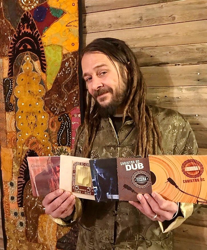 Певец и продюсер Христофер Врениос (Christos DC) держит в руках диски со своими альбомами. Фото сделано явно ранее 2020 года, поскольку с тех пор альбомов в дискографии поприбавилось ;)
