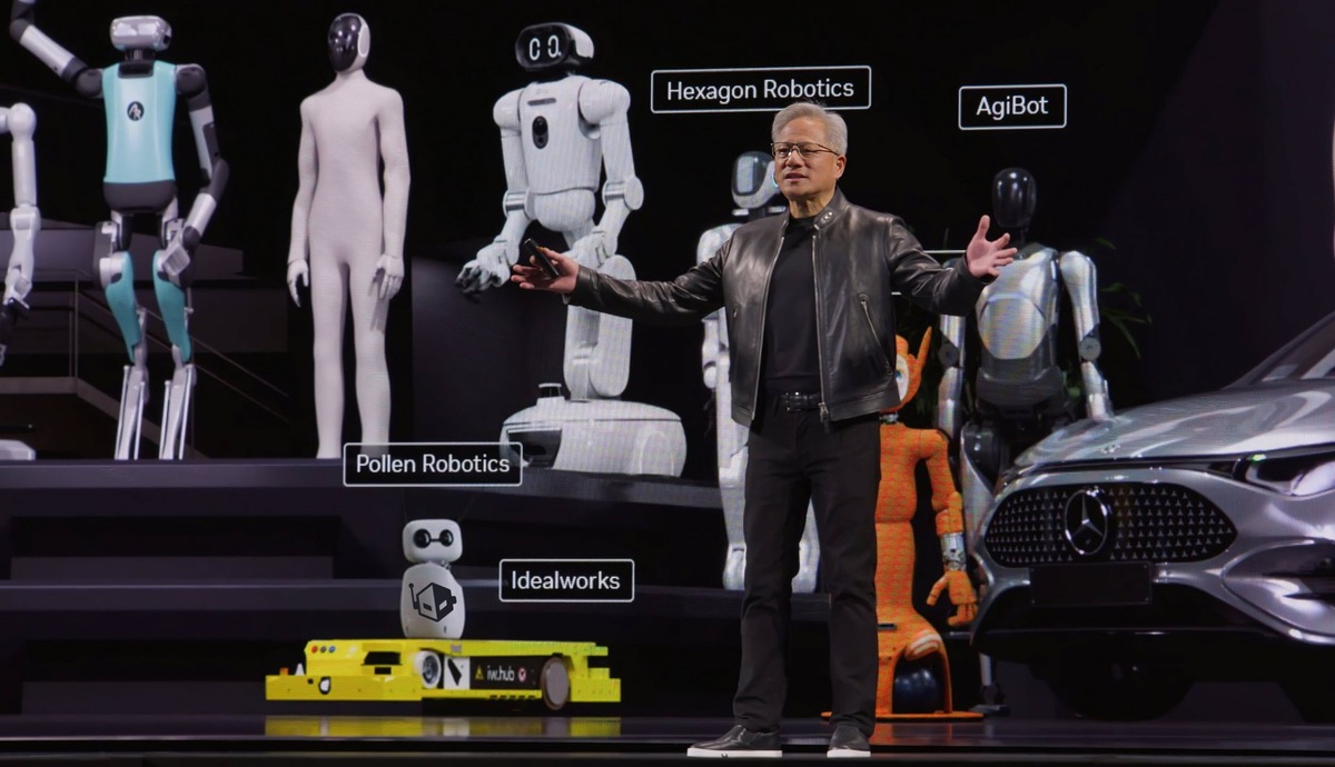    Man in a leather jacket presenting on a stage with multiple humanoid robots and a Mercedes car in the background, labeled with company names like Hexagon Robotics and Pollen Robotics.