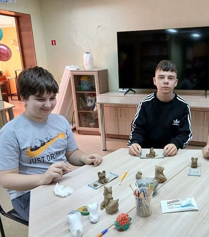 Два мальчика-подростка слепили фигурки из глины
