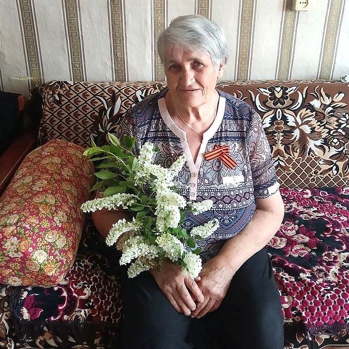 Пожилая женщина с букетом цветов