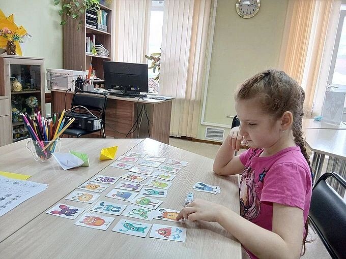 Девочка играет в настольную карточную игру