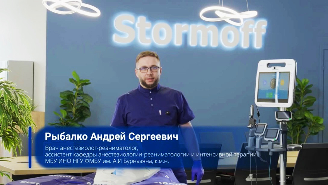 Андрей Сергеевич Рыбалко, врач анестезиолог-реаниматолог, рядом со стойкой Insighters, на которой размещены все виды видеоларингоскопов Insighters