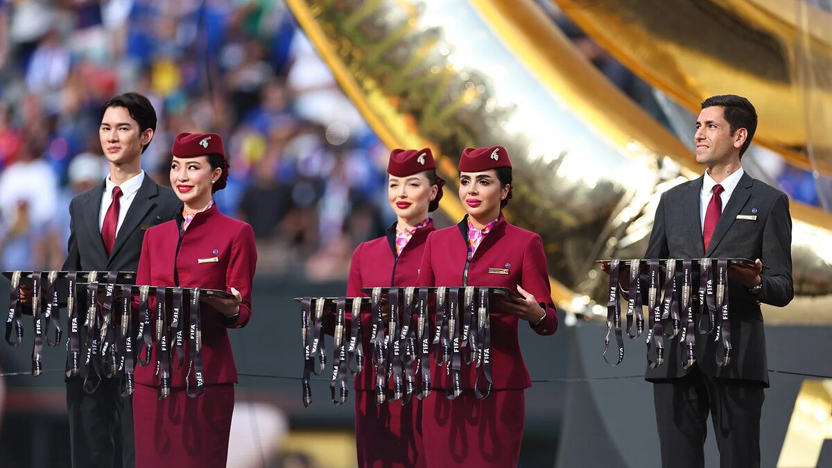 Сотрудники Qatar Airways держат медали победителей финального матча клубного чемпионата мира по футболу 2025 между «Челси» и «Пари Сен-Жермен» на стадионе «Метлайф», 2025 год (Фото Jay Barratt - AMA / Getty Images)