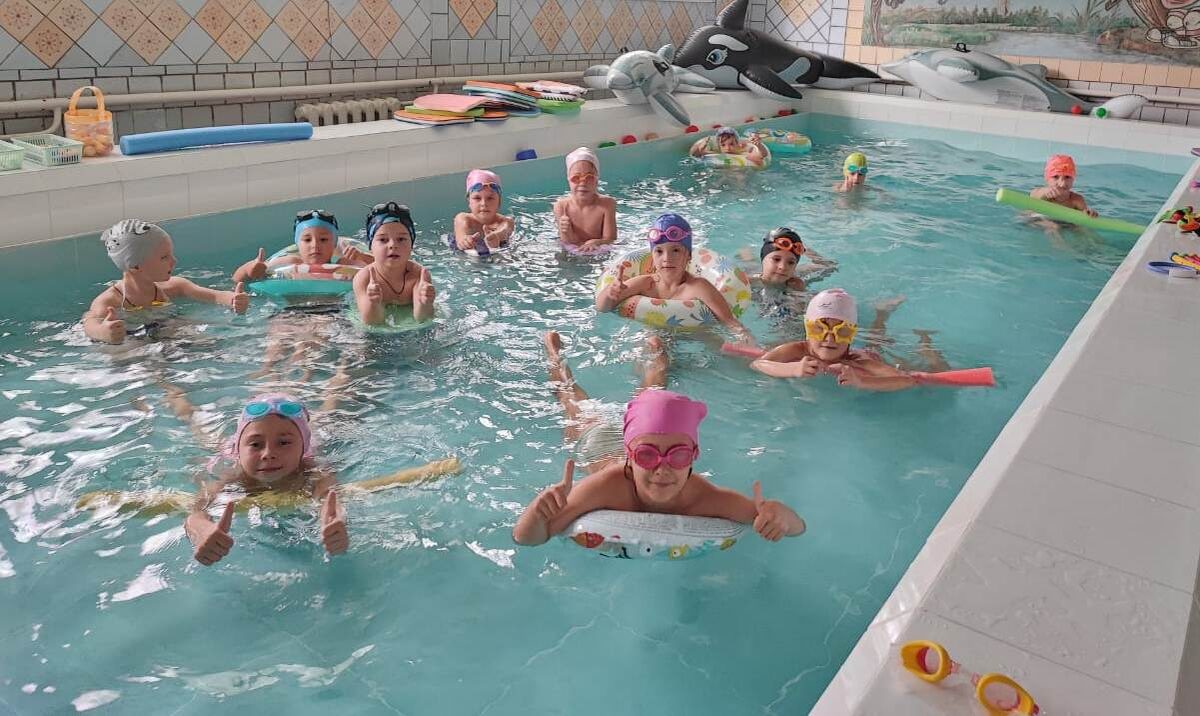 В бассейне малышей обучают плаванию.