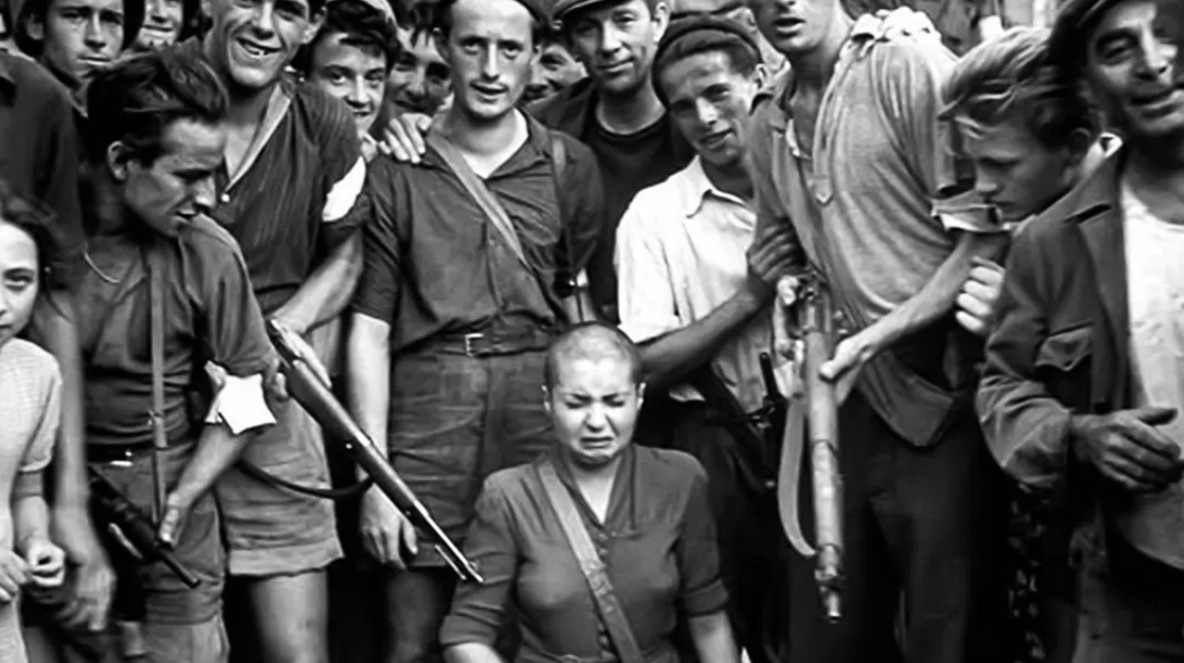 Шартр, август 1944 года. Женщину, обвинённую в связи с немецким солдатом, ведут по улицам после публичного бритья головы. Фото Роберта Капы стало одним из символов “дикой чистки” во Франции.