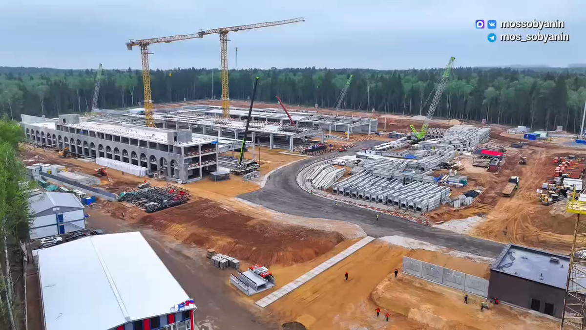 📷 1.1: Общий вид на стройплощадку электродепо «Новорижское». Видны корпуса, краны, зоны складирования железобетонных элементов и временные строительные дороги.
