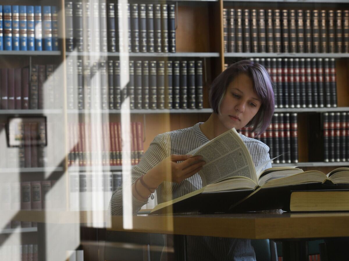    Девушка читает книгу в библиотеке© РИА Новости . Кирилл Каллиников