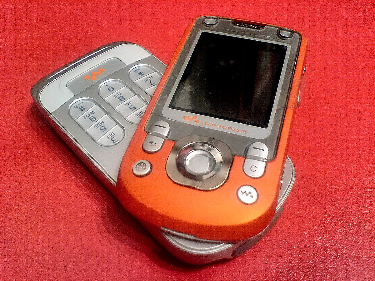 Культовый кнопочный мобильный телефон Sony Ericsson Walkman оранжевого цвета из двухтысячных годов