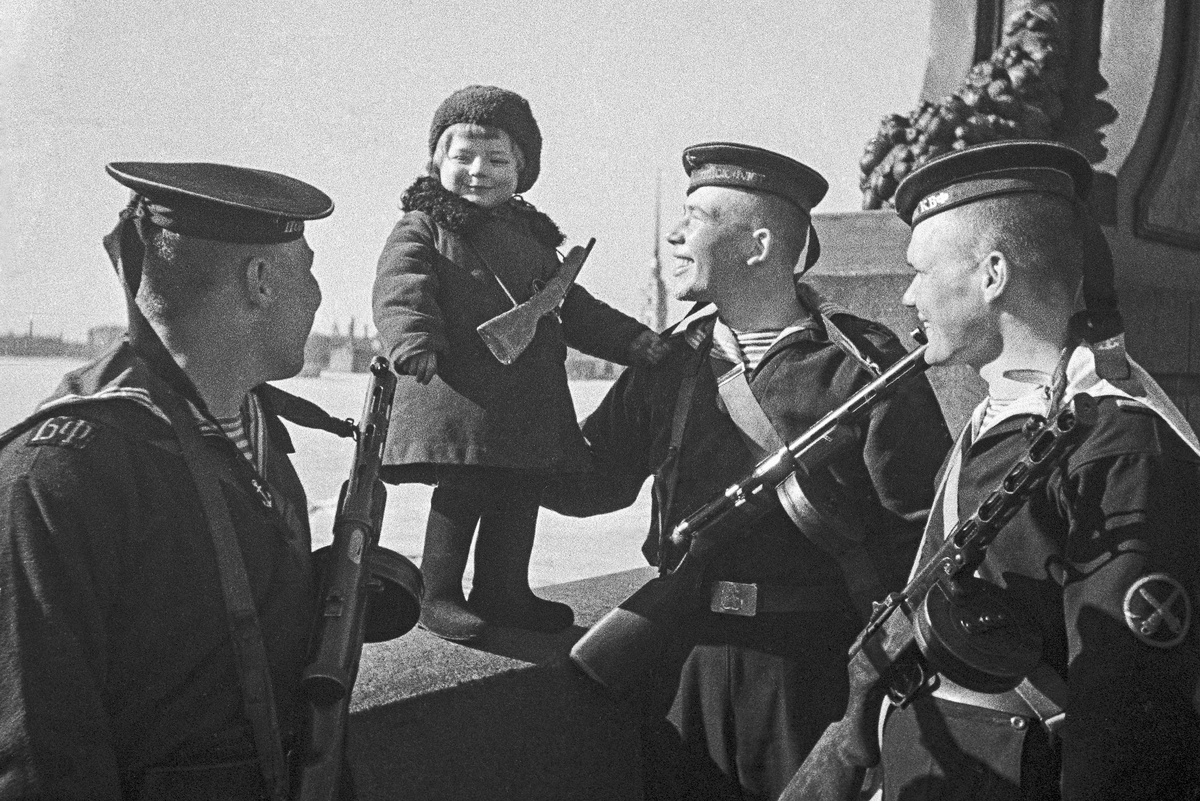   1943 год. Великая Отечественная война. Блокадный Ленинград. Моряки Балтийского флота беседуют с девочкой Люсей. Её и других детей вывозят из блокадного города. Девочка осталась сиротой - её родители умерли от голода. /Борис Кудояров / РИА Новости