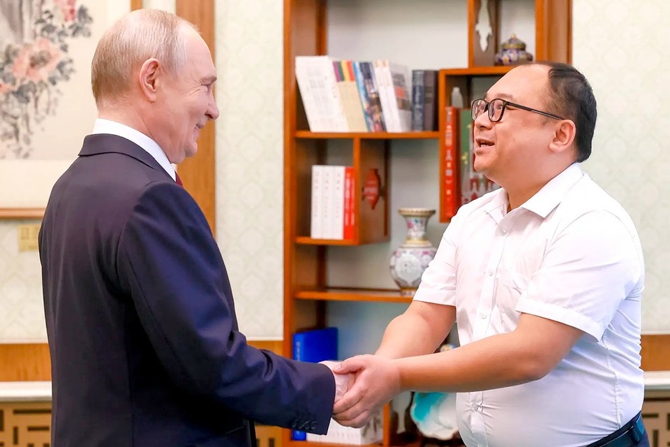    Президент России Владимир Путин и инженер Пэн Пай. REUTERS