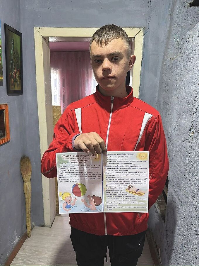 Мальчик-подросток показывает выданную ему памятку