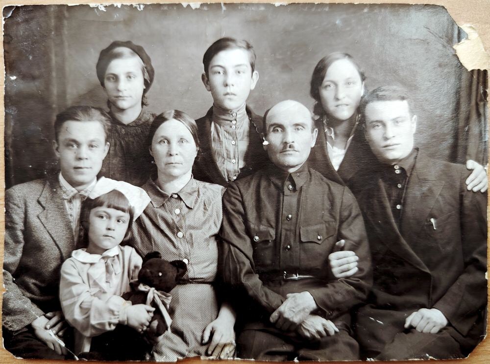 В верхнем ряду, слева направо стоят: младшая сестра Рыбакова Д.К. – Рыбакова Мария Куприяновна, младший брат Рыбакова Д.К. – Рыбаков Фёдор Куприянович и старшая сестра Рыбакова Д.К. – Рыбакова Екатерина Куприяновна. В нижнем ряду сидят, слева направо: зять (муж Рыбаковой Е.К.), у которого на коленях сидит племянница – Гольцова Лидия Алексеевна. Правее мать Рыбакова Д.К. – Рыбакова Анна Ивановна и отец – Рыбаков Куприян Петрович, рядом с которым сидит Рыбаков Дмитрий Куприянович