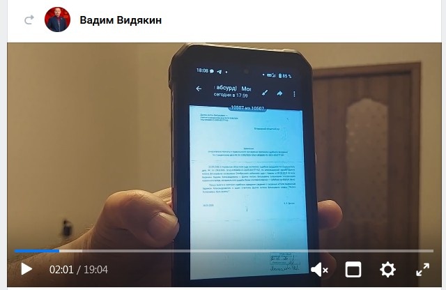 Вадим Видякин используя дуло руки демонстрирует на дуло видеокамеры дуло сотового телефона, где изображено дуло текста, в котором идет речь о неком дуле, которое он хотел бы увидеть залепленным