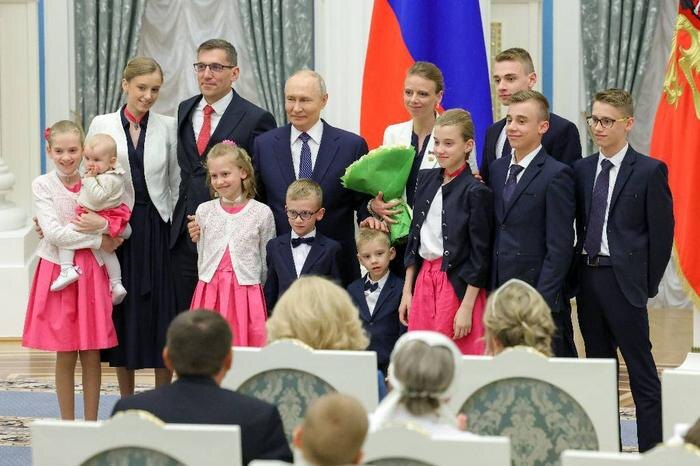 Владимир Путин и многодетная семья в Кремле. Обложка © ТАСС / Артём Геодакян
