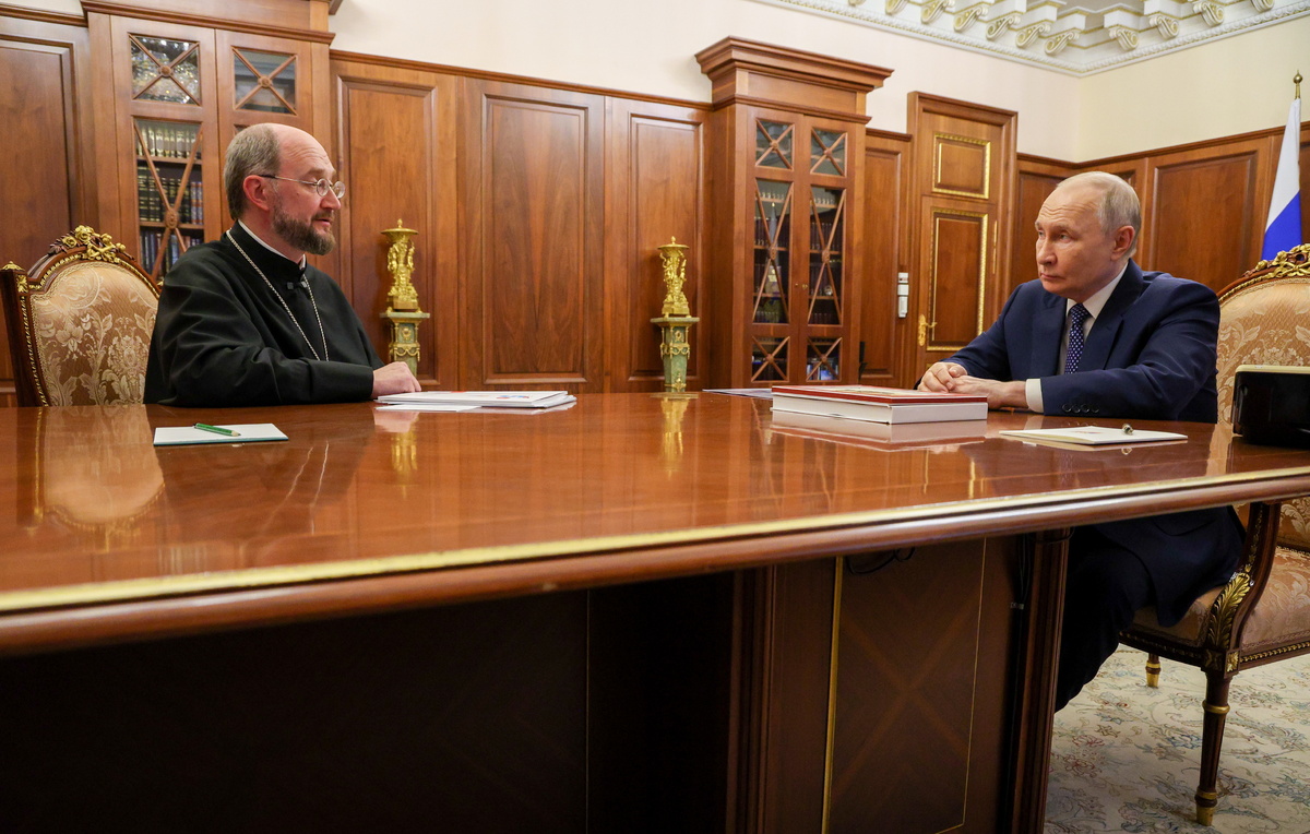    Руководитель фонда "Круг добра" протоиерей Александр Ткаченко и президент России Владимир Путин  Вячеслав Прокофьев/Пресс-служба президента РФ/ТАСС