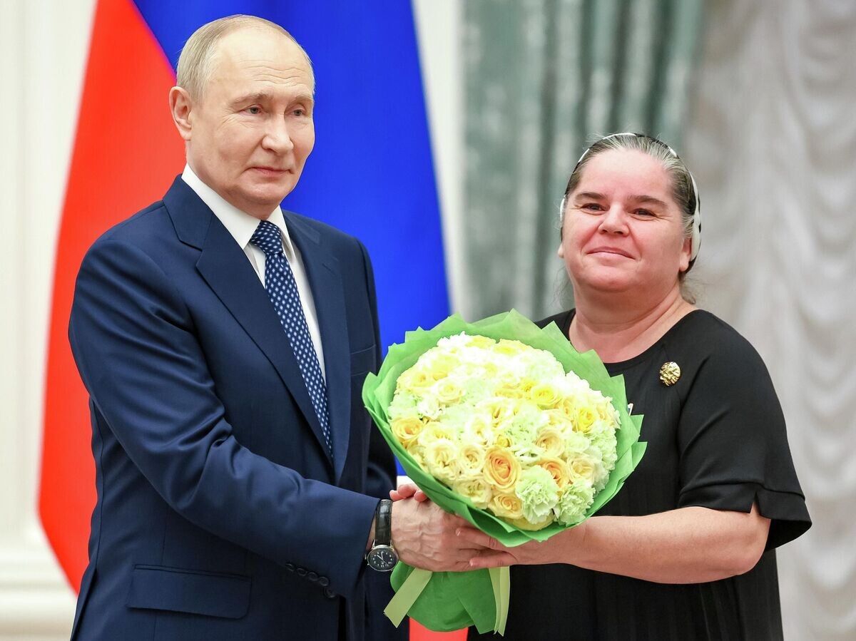    Президент РФ Владимир Путин и Сима Каркусова на церемонии вручения орденов "Мать-героиня" и "Родительская слава" родителям девяти многодетных семей в Кремле | © POOL