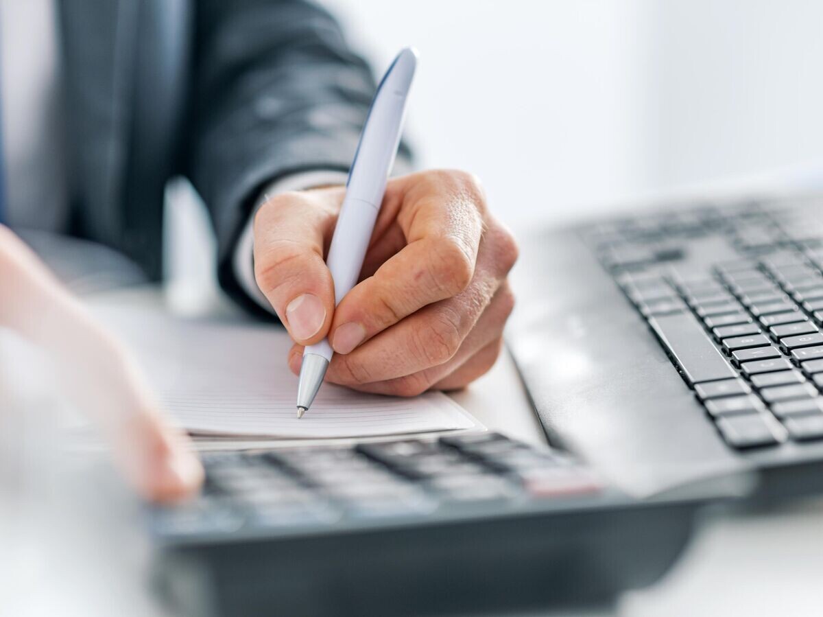    Мужчина подписывает документы в офисе | © iStock.com / ljubaphoto